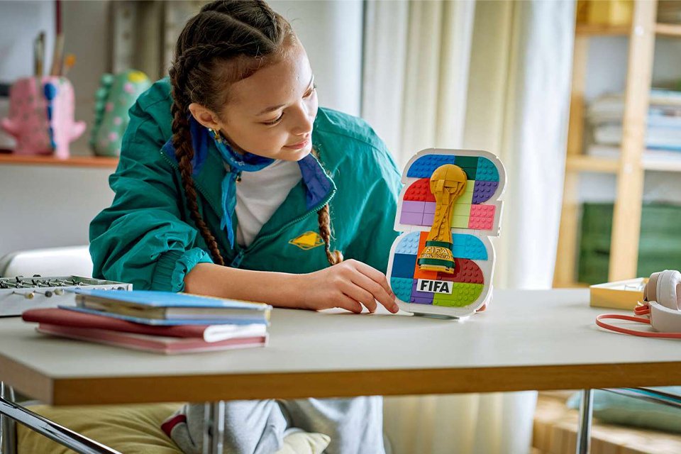Woman admiring the LEGO® Editions Fifa World Cup 2026 Official Emblem set.